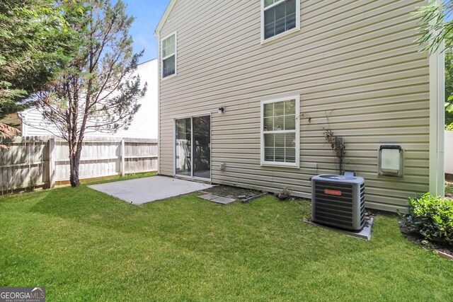 rear view of house featuring a patio area, a yard, and central air condition unit