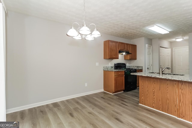 kitchen with a notable chandelier, pendant lighting, sink, black range with gas cooktop, and a textured ceiling