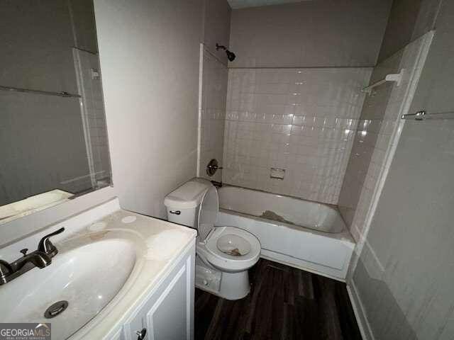 full bathroom with shower / tub combination, hardwood / wood-style flooring, vanity, and toilet