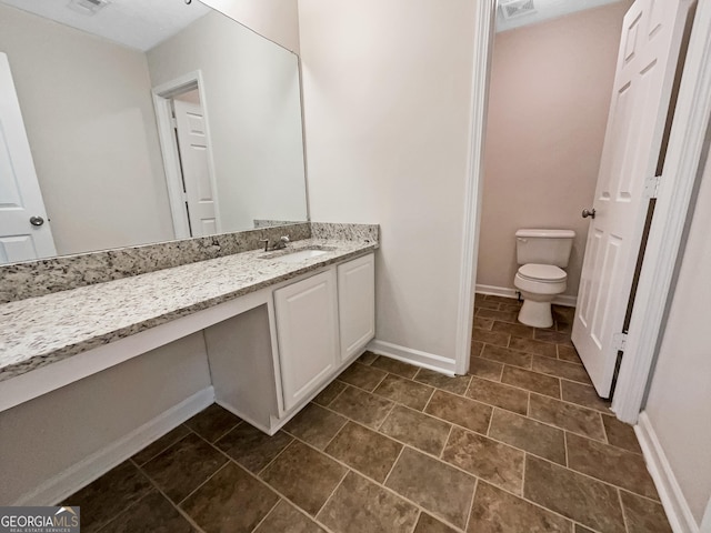 bathroom featuring toilet and vanity