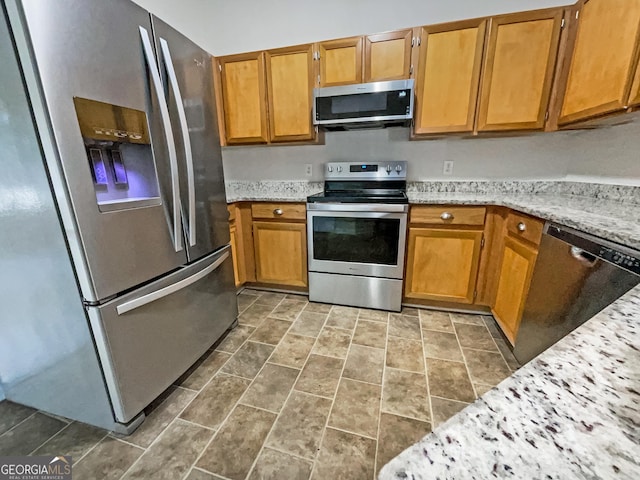 kitchen featuring light stone countertops and stainless steel appliances