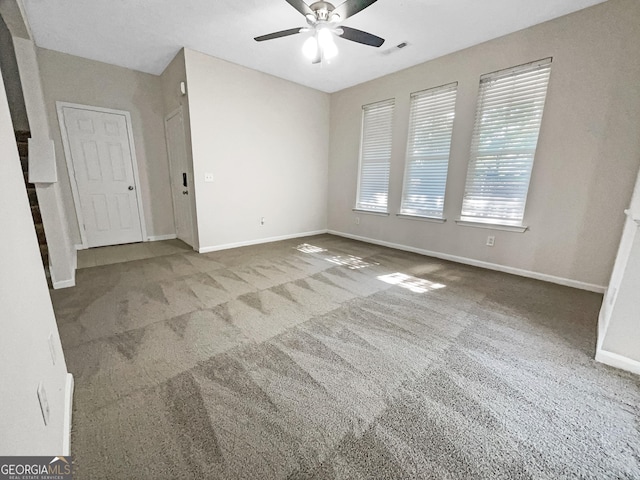 carpeted spare room featuring ceiling fan and a healthy amount of sunlight