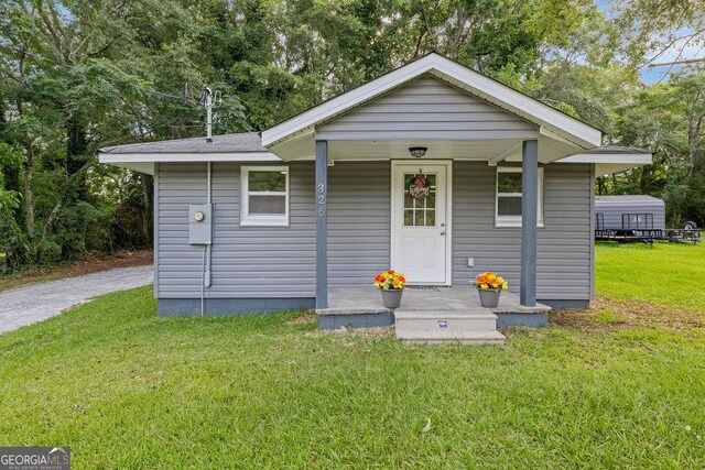 bungalow-style house with a front yard and covered porch