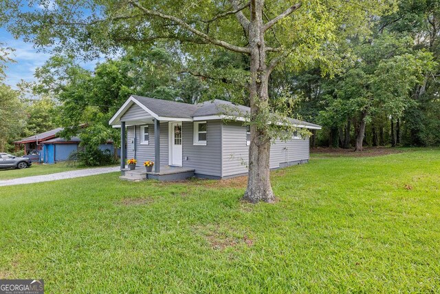 view of front facade with a garage, an outbuilding, and a front lawn