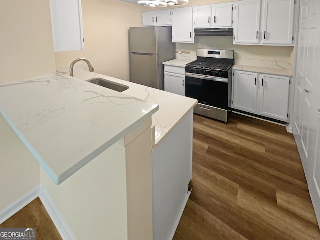 kitchen with kitchen peninsula, stainless steel appliances, and white cabinetry