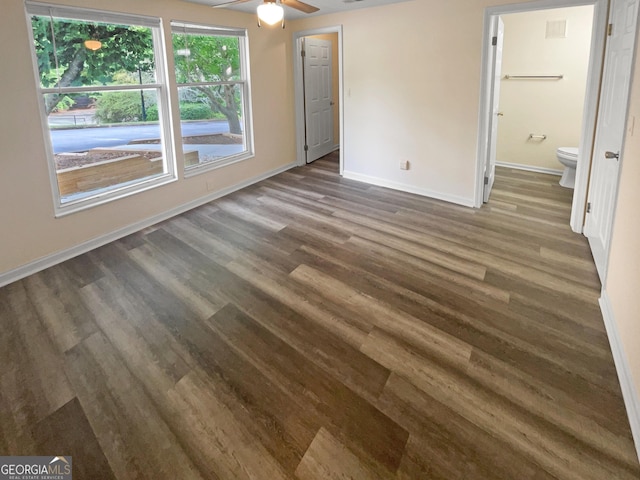 unfurnished bedroom with dark hardwood / wood-style flooring, ensuite bath, and ceiling fan