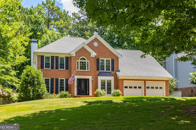 colonial home featuring a garage and a front yard