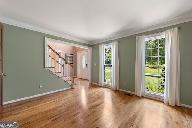 empty room with light hardwood / wood-style floors and ornamental molding