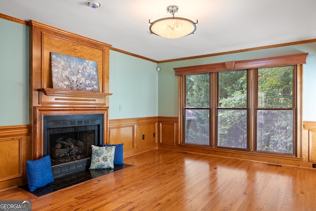 unfurnished living room with a fireplace, light wood-type flooring, and ornamental molding