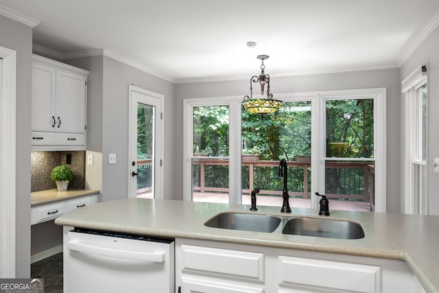 kitchen with pendant lighting, tasteful backsplash, white cabinetry, white dishwasher, and sink