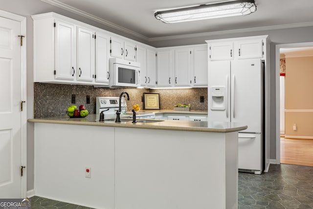 kitchen with sink, dark hardwood / wood-style flooring, white appliances, white cabinetry, and kitchen peninsula