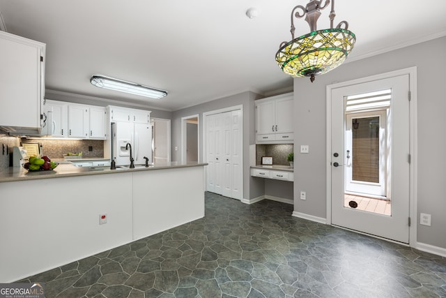 kitchen with dark tile patterned floors, decorative backsplash, white cabinetry, kitchen peninsula, and white fridge with ice dispenser