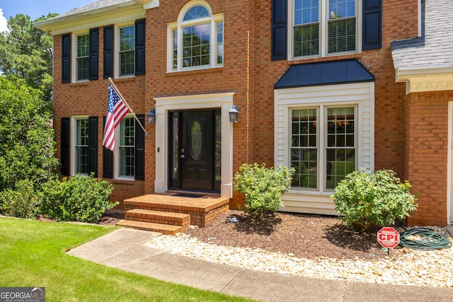 property entrance featuring a standing seam roof, brick siding, and metal roof