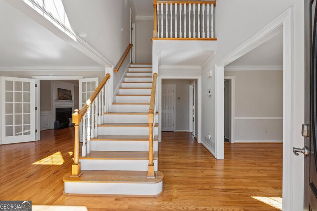 foyer with light wood-type flooring and crown molding