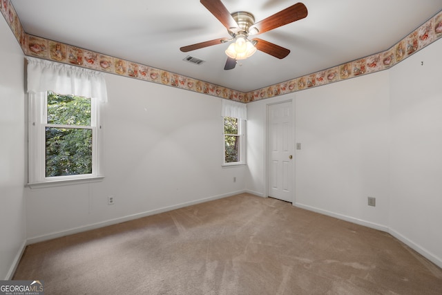 carpeted empty room featuring ceiling fan and plenty of natural light