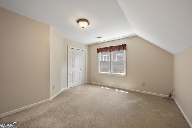 additional living space featuring vaulted ceiling and carpet floors