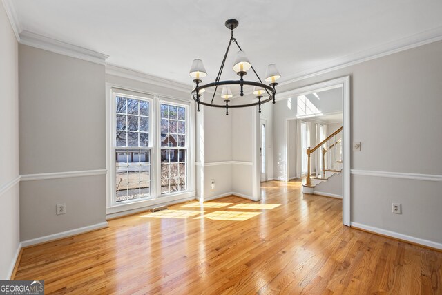 entryway featuring light wood-type flooring, a wealth of natural light, and a notable chandelier