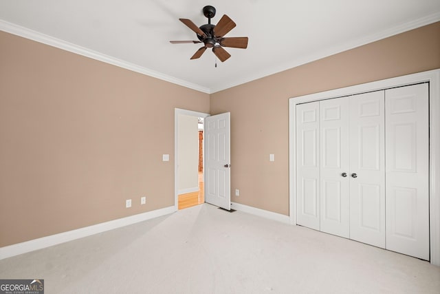 unfurnished bedroom with ceiling fan, light colored carpet, crown molding, and a closet