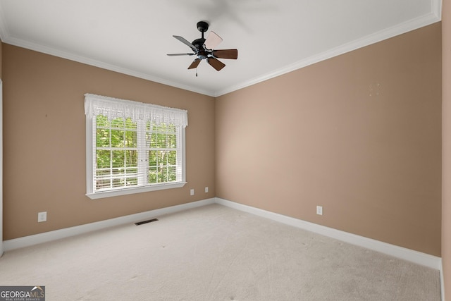 carpeted empty room featuring ceiling fan and crown molding