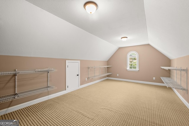 bonus room with carpet floors and vaulted ceiling