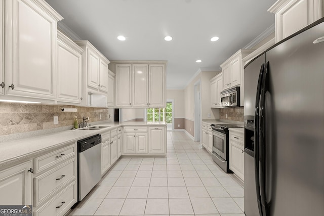 kitchen with white cabinetry, sink, tasteful backsplash, crown molding, and appliances with stainless steel finishes