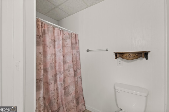 bathroom featuring a paneled ceiling and toilet