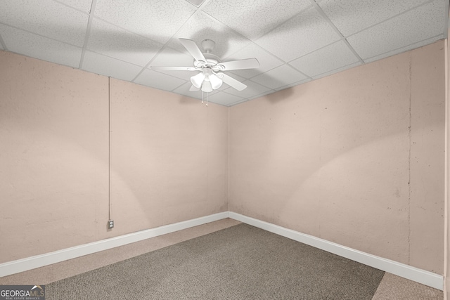 carpeted spare room featuring a drop ceiling and ceiling fan