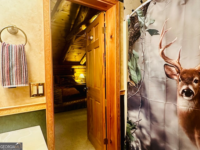 corridor featuring lofted ceiling, carpet flooring, and wooden ceiling