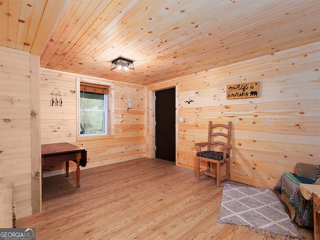 sitting room with wood ceiling, wood-type flooring, and wooden walls