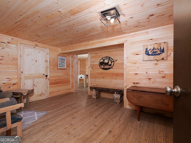 interior space with wood ceiling, hardwood / wood-style flooring, and wooden walls