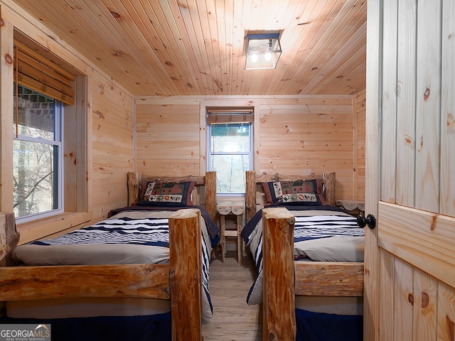 bedroom featuring wood walls, wooden ceiling, and hardwood / wood-style floors