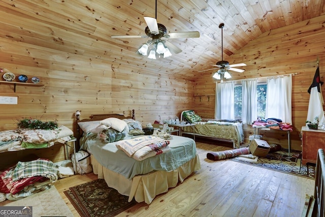 bedroom with ceiling fan, wooden ceiling, and wood walls