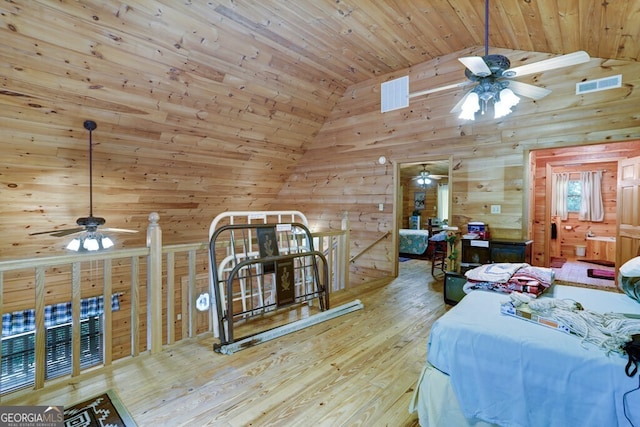 bedroom with light wood-type flooring, lofted ceiling, wooden walls, and wooden ceiling