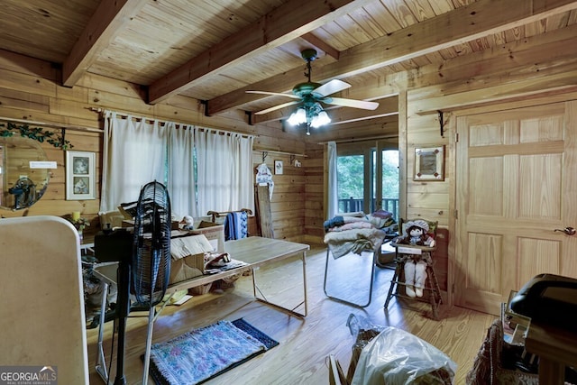 dining space with wooden walls, beamed ceiling, light hardwood / wood-style floors, and wooden ceiling