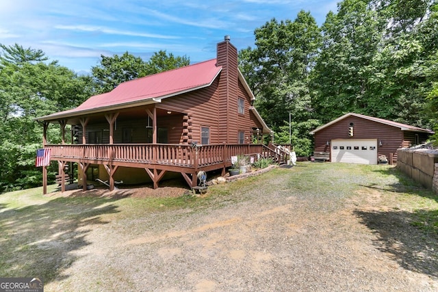 log home featuring a garage and an outdoor structure