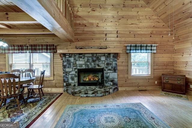 living room with wooden walls, hardwood / wood-style floors, and a healthy amount of sunlight