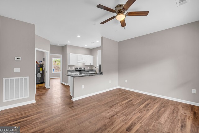 kitchen featuring dark stone counters, white cabinets, kitchen peninsula, dark hardwood / wood-style flooring, and ceiling fan