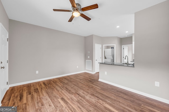 unfurnished living room featuring ceiling fan, sink, and hardwood / wood-style flooring