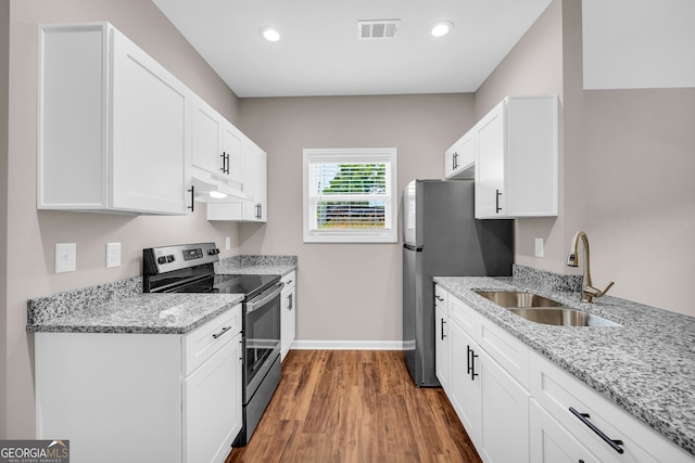 kitchen with wood-type flooring, stainless steel appliances, white cabinets, sink, and light stone countertops