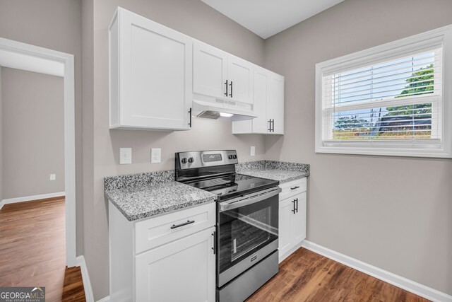 kitchen with white cabinetry, dark hardwood / wood-style flooring, stainless steel range with electric cooktop, and light stone counters