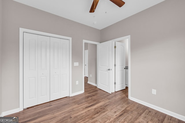 unfurnished bedroom featuring a closet, wood-type flooring, and ceiling fan