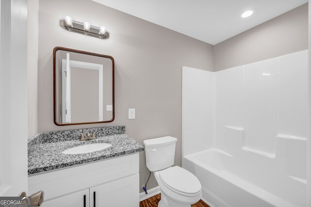 full bathroom featuring hardwood / wood-style flooring, bathtub / shower combination, toilet, and vanity