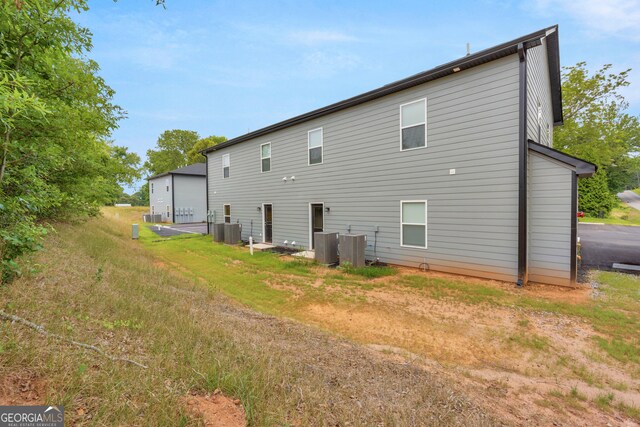 rear view of house featuring central AC unit