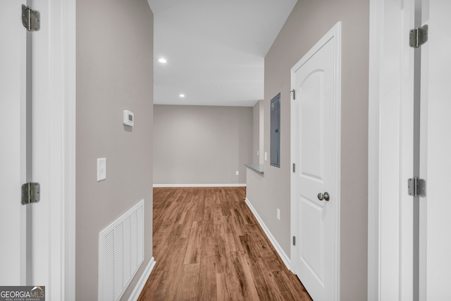 hallway with wood-type flooring and electric panel