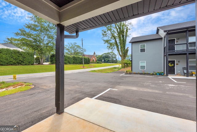 view of parking / parking lot with a lawn