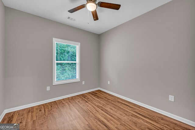 empty room with hardwood / wood-style flooring and ceiling fan