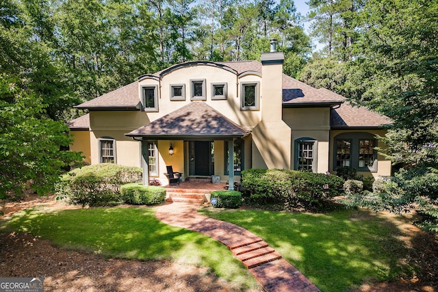 french country style house featuring a front yard and covered porch