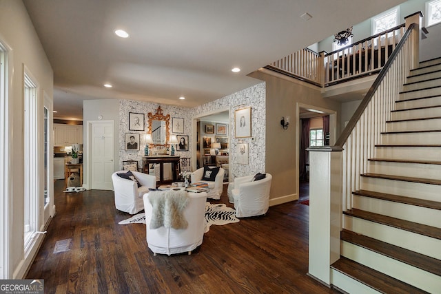 living room featuring dark wood-type flooring and a stone fireplace