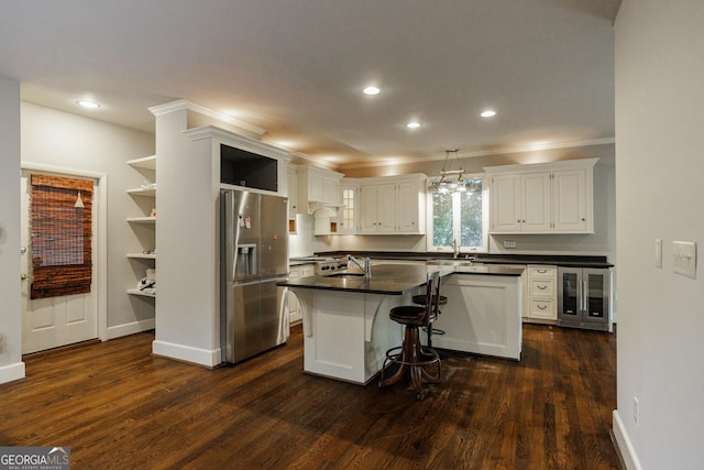 kitchen featuring white cabinetry, a breakfast bar area, stainless steel fridge, a kitchen island, and wine cooler