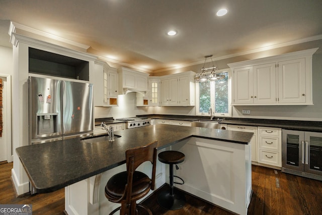 kitchen featuring a kitchen island, stainless steel fridge, pendant lighting, and sink